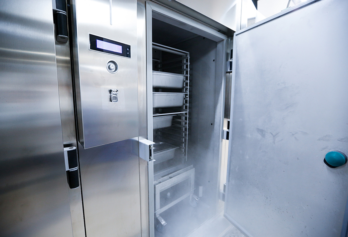 Blick in geöffnete Edelstahl-Kühlzelle mit Kälteausstoß