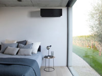 Schwarzes Daikin-Klimagerät über dem Bett in modernem Schlafzimmer mit Ausblick