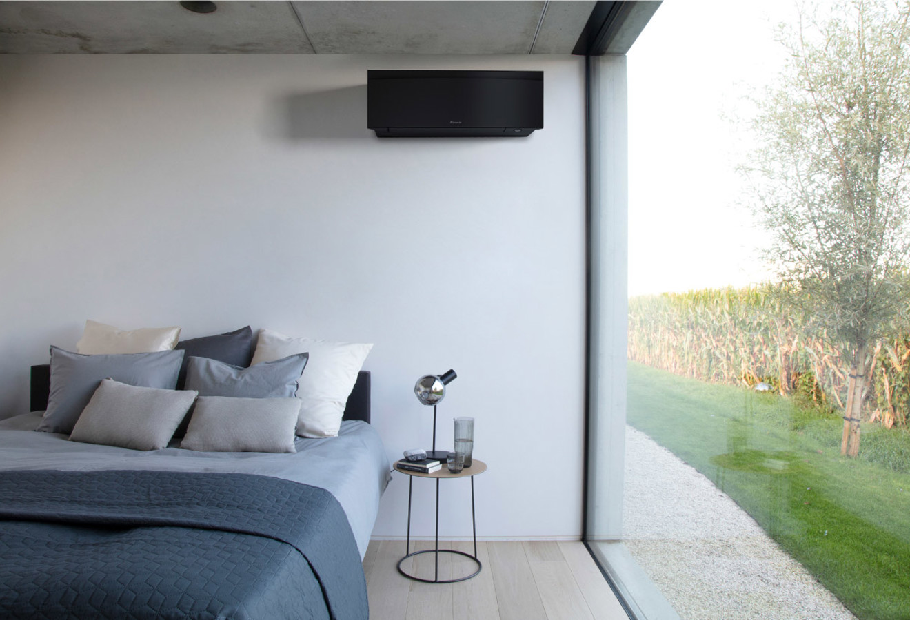 Schwarzes Daikin-Klimagerät über dem Bett in modernem Schlafzimmer mit Ausblick
