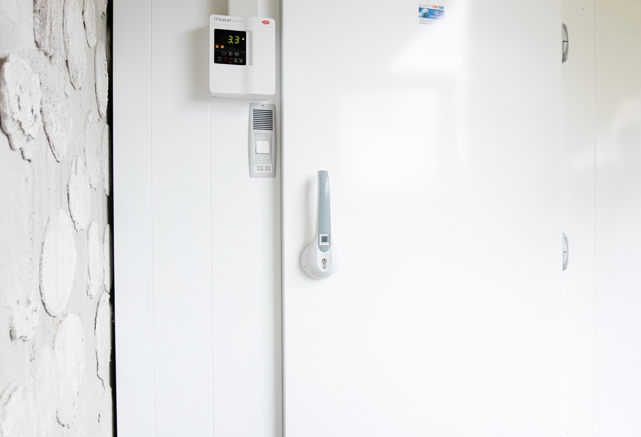 Weiße Tür einer begehbaren Kühlzelle mit Steuerung