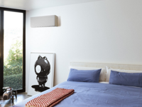 Weißes Daikin-Klimagerät an Schlafzimmerwand mit großem Fenster