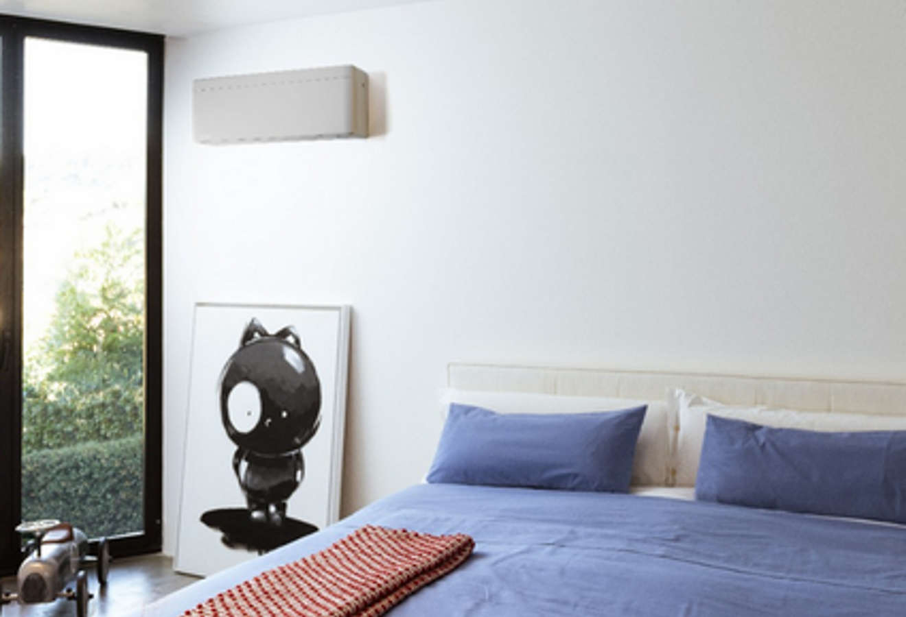 Weißes Daikin-Klimagerät an Schlafzimmerwand mit großem Fenster