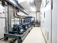 Industriekälteanlage mit Kompressoren und Kältemaschinen in einem Technikraum.
